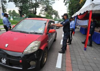 KAKITANGAN MBJB menyampaikan pek bubur lambuk kepada orang ramai secara pandu lalu sempena Program Bubur Lambuk Mega MBJB dan Yayasan JDT di TMIYC , Johor Bahru di sini. - UTUSAN/RAJA JAAFAR ALI