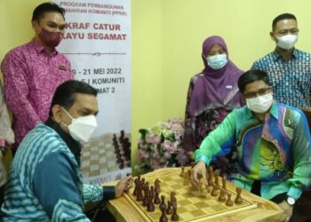 R. Santhara Kumar (kiri) mencuba permainan catur selepas merasmikan penutupan Program Pembangunan Kemahiran Komuniti Kraf Catur Kayu Segamat di Kolej Komuniti Segamat 2, Johor.