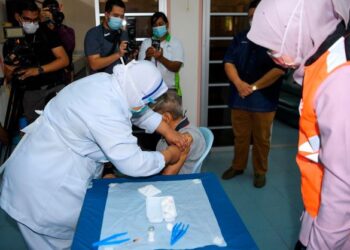 SEORANG warga emas menerima suntikan vaksin Covid-19 di Sikamat, Seremban. JKM menetapkan setiap pusat jagaan perlu berdaftar agar kebajikan penghuninya terbela sepenuhnya. - GAMBAR HIASAN