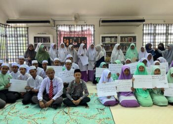 MOHD. Shamsul Baharin Isa (duduk, tengah) bersama guru dan pelajar dalam  Program Nuzul al-Quran anjuran Perpustakaan Awam cawangan Gua Musang di Bandar Baru, Gua Musang, Kelantan semalam. -UTUSAN/AIMUNI TUAN LAH