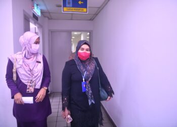 NORAZIA Abdul Rahman (kanan) yang dituduh memberi perkhidmatan memutihkan gigi tanpa lesen dibawa keluar dari Mahkamah Sesyen Kuala Terengganu, Terengganu, hari ini. - UTUSAN/PUQTRA HAIRRY ROSLI