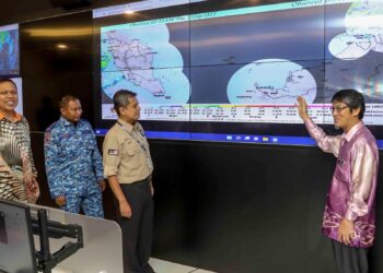 PEGAWAI kanan Agensi Pengurusan Bencana Negara (Nadma) dan Jabatan Meteorologi Malaysia melihat peta menunjukkan kawasan yang berisiko menghadapi banjir di Pusat Kawalan Bencana Negara (NDCC), Puchong, Selangor pada 15 September lalu. – UTUSAN/FAISOL MUSTAFA