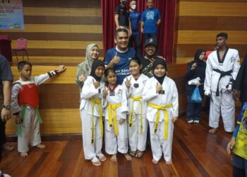 RADZI Jidin bersama isteri, Balkis Zakaria (kiri) bergambar bersama peserta Kejohanan Taekwando Terbuka Putrajaya di Kompleks Kejiranan Presint 11, Putrajaya. - UTUSAN/MOHD HUSNI MOHD NOOR