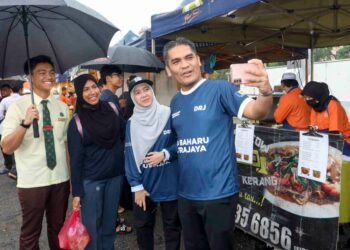 RADZI Jidin berswafoto dengan pengunjung di Pasar Tani Presint 2, Putrajaya.- UTUSAN/FAISOL MUSTAFA