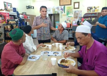 RADZI Jidin menyantuni pengundi luar Putrajaya yang menetap di Desa Pinggiran Putra, Kajang.