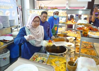 FUZIAH Salleh membantu penyediaan Menu Rahmah di Restoran Nasi Kandar Padang Kota di Mydin Taman Rinting, Pasir Gudang, Johor Bahru.