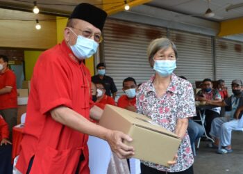 RAIS Yatim (kiri) menyerahkan sumbangan kepada penerima dalam Program Jalinan Muhibah di Simpang Durian, Jelebu, Negeri Sembilan, hari ini. UTUSAN/ZAKKINA WATI AHMAD TARMIZI