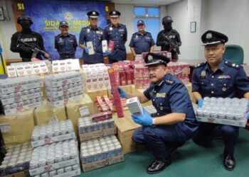 HAMISAN KALIP (duduk kiri) menunjukkan antara barangan dagangan yang dirampas daripada satu sindiket penyeleludupan dalam sidang akhbar di Butterworth, Pulau Pinang hari ini.