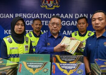 NIK Yusaimi Yussof (tengah) menunjukkan sebahagian naskhah dan bahan al-Quran yang dirampas dalam Ops Mulia di Kuala Terengganu, Terengganu, hari ini. - UTUSAN/PUQTRA HAIRRY ROSLI
