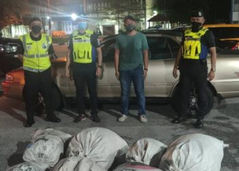 TUJUH guni berisi daun ketum yang disembunyikan dalam sebuah kereta di kawasan R&R Behrang arah selatan dekat Tanjung Malim, Perak,  kelmarin. - IHSAN PDRM