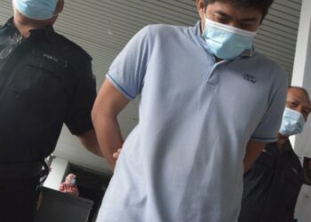 RASHIDEE Abd. Razak (tengah) diiringi anggota polis selepas dihadapkan ke Mahkamah Sesyen atas pertuduhan menyebabkan kematian suami kepada bekas isterinya serta mencederakan wanita itu pada bulan lalu di Kompleks Mahkamah di Ayer Keroh, Melaka. UTUSAN/ DIYANATUL ATIQAH ZAKARYA