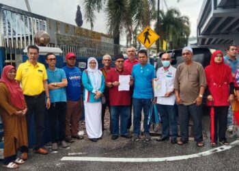 WAN Ibrahim Wan Yusoff (tengah) menunjukkan laporan polis yang dibuat di IPD Tanah Merah, Kelantan berhubung dakwaan sogokan wang pada PRU15. - UTUSAN/ROSMIZAN RESDI