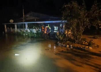 Anggota bomba membantu memindahkan mangsa banjir di Raub malam tadi.