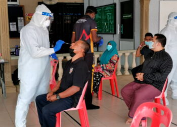 PENDUDUK menjalani ujian calitan berikutan pelaksanaan PKPD di Taman Melur Fasa 1 di Teluk Intan, Perak. - UTUSAN/AIN SAFRE BIDIN