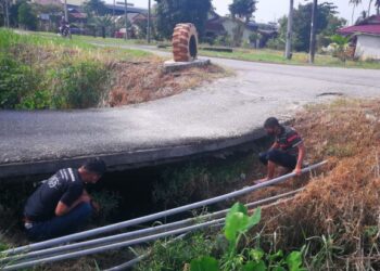 PENDUDUK Kampung Sementa Kapar menunjukkan keadaan jambatan yang dibina sejak 15 tahun lalu usang dan tiang kayu digunakan untuk menyokongnya juga patah.. - UTUSAN / ABDUL RAZAK IDRIS