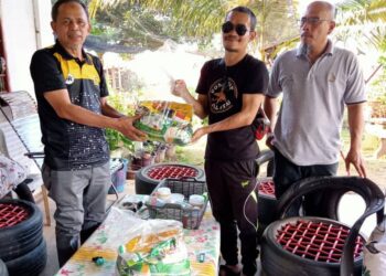 RAZAK Daud (kiri) menyampaikan sumbangan Ramadan kepada golongan kurang berkemampuan di Felda Jengka 24 di Jerantut, Pahang.