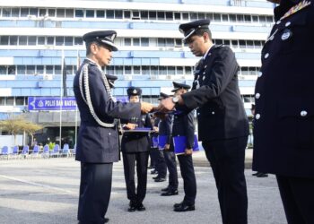 ABDUL RAZAK Mohd. Yusoff (kiri) menyampaikan sijil kepada anggota polis pada hari terakhir perkhidmatannya di Ibu Pejabat Polis Kontinjen (IPK) Pahang di Kuantan, Pahang. - FOTO/SHAIKH AHMAD RAZIF