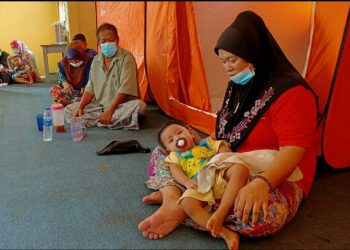 NORIZAH Mohd. Nor (kanan, duduk) bersama cucunya yang berpindah ke PPS di SK Gual Sitok, Rantau Panjang selepas rumah mereka dinaiki air. - YATIMIN ABDULLAH