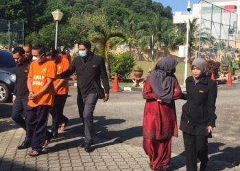TIGA individu yang didakwa mengemukakan tuntutan palsu kepada Perkeso dibawa di Kompleks Mahkamah Kuala Terengganu di Kuala Terengganu, hari ini. - UTUSAN/TENGKU DANISH BAHRI TENGKU YUSOFF