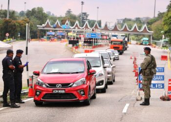 Anggota polis melakukan pemeriksaan   di Plaza Tol Ayer Keroh ketika pengumuman amanat khas Perdana Menteri, Datuk Seri Ismail Sabri Yaakob semalam. Ini merupakan antara wira yang tidak didendang yang membantu negara untuk bangkit semula ekoran pandemik Covid-19. - UTUSAN/ RASUL AZLI SAMAD