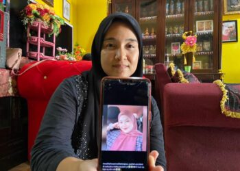 INTAN Liana Nordin menunjukkan gambar 
Nurul Emylia Natasha Zulkifli ketika ditemui di Kampung Pulau Lima, Pasir Puteh, Kelantan hari ini. - UTUSAN/TOREK SULONG