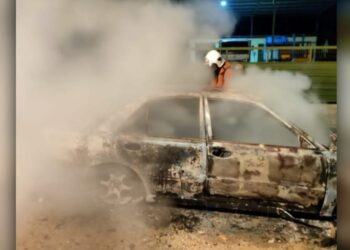 ANGGOTA bomba memadam kebakaran sebuah kereta dalam kejadian di Taman Jaya, Bahau, Jempol, Negeri Sembilan.- IHSAN BOMBA