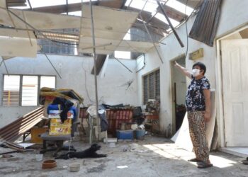 SEORANG penduduk menunjukkan kerosakan rumahnya yang dibadai ribut di Kampung Tawas, Ipoh, Perak.