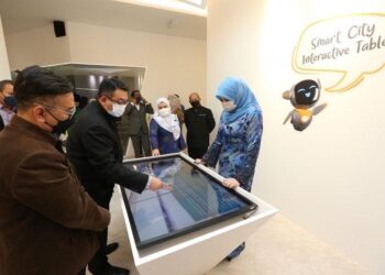 RINA Mohd. Harun mendengar penerangan daripada Amirudin Abdul Wahab berhubung pengoperasian agensi tersebut di Menara CyberSecurity Malaysia, Cyberjaya.