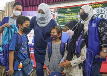  RINA Harun (tengah) menyampaikan sumbangan peralatan dan barangan persekolahan ketika Program Back To School peringkat Titiwangsa kepada kanak-kanak penduduk PPR parlimen Titiwangsa di Dewan Al-Akram, Masjid Al-Akram, Datuk Keramat di sini hari ini. - UTUSAN/AMIR KHALID 
