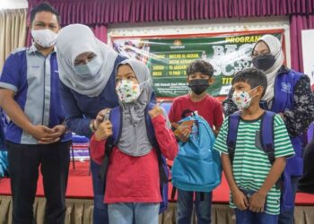 RINA Harun (tengah) menyampaikan sumbangan peralatan dan barangan persekolahan ketika Program Back To School peringkat Titiwangsa kepada kanak-kanak penduduk PPR Parlimen Titiwangsa di Dewan Al-Akram, Masjid Al-Akram, Datuk Keramat, hari ini. - -UTUSAN/AMIR KHALID 