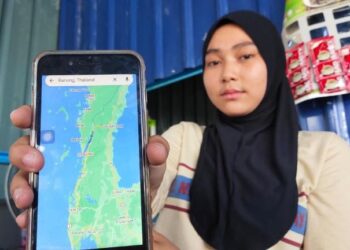 NORLELA AYOB menunjukkan kedudukan daerah Ranong di telefon pintarnya di Titi Tinggi, Padang Besar, Perlis hari ini. - UTUSAN/SYED AZLAN SAYID HIZAR