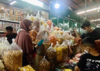 Zainab Abdul Aziz (kiri) melayan pelanggan yang datang ke kedainya di Padang Waremart, Padang Besar, Parlis. – UTUSAN/SYED AZLAN SAYID HIZAR