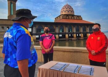 TUANKU SYED Faizuddin Putra Jamalullail (kanan) menyampaikan sumbangan zakat Majlis Agama Islam dan Adat Istiadat Melayu Perlis (MAIPs) kepada 30 orang asnaf terpilih Masjid Al Mukminin, Kampung Kota Kayang di pekarangan Masjid Terapung Al Hussain Kuala Perlis, hari ini.