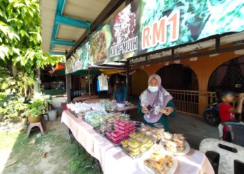 SITI Maimunah Deraman menunjukkan kuih-muih RM1 sebungkus yang dijual di gerainya di Kampung Tanjong Baru, Taman Buaya, Kota Bharu, Kelantan. - UTUSAN/YATIMIN ABDULLAH