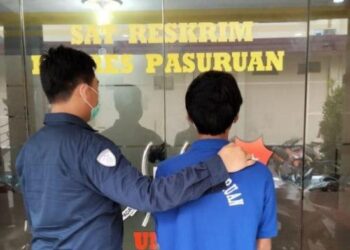 SEORANG suspek rogol gadis bawah umur secara bergilir-gilir (kanan) dibawa ke balai polis Pasuruan,Jawa Timur. - Tribunenews