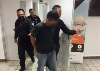 TERTUDUH (tengah) yang dijatuhi hukuman penjara 19 tahun selepas mengaku bersalah merogol anak tirinya dibawa keluar dari Mahkamah Sesyen Kuala Terengganu, Kuala Terengganu, hari ini. - UTUSAN/TENGKU DANISH BAHRI TENGKU YUSOFF