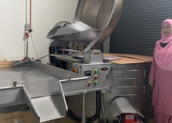 SITI Rohani Sadikun bersama salah satu mesin bagi menghasilkan produk Belinjo Gold.