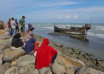 PENDUDUK Acheh melihat bot yang membawa pelarian Rohingya yang terdampar di pantai wilayah itu, baru-baru ini. - AFP