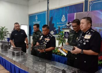 KAMARUL ZAMAN MAMAT (tengah) menunjukkan rokok seludup yang dirampas dalam sidang akhbar di Ibu pejabat Polis Daerah Kluang, hari ini.