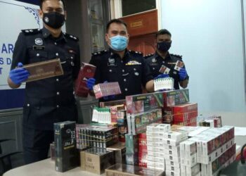 BAHRIN Mohd. Noh (tengah) bersama rampasan rokok pelbagai jenama dalam serbuan baru-baru ini ketika sidang akhbar di IPD Segamat, Johor.
