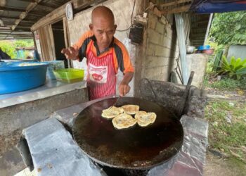 MD. Kamil Abdullah melayan menyiapkan tempahan roti canai murah di Kampung Padang Pak Amat, Jalan Jeram Pasu, Pasir Puteh, Kelantan hari ini. -UTUSAN/TOREK SULONG