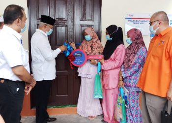 NAJMI Ahmad menyerahkan kunci rumah kepada Nur Shafinah Said dalam majlis Kesyukuran Projek Baiti Jannati TNB 2020 di Kampung Seberang Ketil, Kupang, Kedah, semalam.  – UTUSAN/NORLIA RAMLI