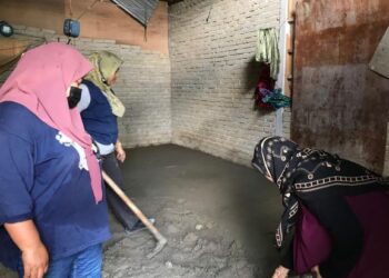 ANGGOTA Rela bersama Persatuan Cakna Kasih Gua Musang membantu menyiapkan lantai rumah yang menjadi tempat tinggal dua beranak di Kampung Kuala Betis, Gua Musang, Kelantan, hari ini. - FOTO/AIMUNI TUAN LAH