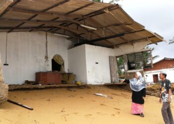 WAN Ahmad Darus Wan Musa melihat keadaan rumah Normah Mahmud yang runtuh akibat hakisan pantai dalam fenomena air laut pasang besar di Kampung Geliga Baru, Kemaman, Terengganu, hari ini. - UTUSAN/NIK NUR IZZATUL HAZWANI NIK ADNAN