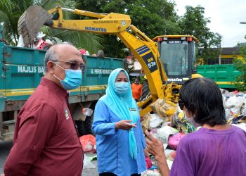 DR. Wan Norashikin Wan Noordin berbual dengan Chung Sook Khuan ketika operasi membersihkan sampah sarap di kediaman wanita itu di Taman Bersatu, Simpang Pulai, semalam. – UTUSAN/ZULFACHRI ZULKIFLI