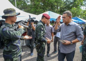 SAIFUDIN Nasution Ismail (tengah) beramah mesra dengan anggota Pasukan Gerakan Am (PGA) yang bertugas mengawal sempadan negara ketika mengadakan lawatan dan penyampaian sumbangan Aidilfitri di Markas Taktikal (MARTAK) Bukit Kayu Hitam, Kedah.- UTUSAN/ SHAHIR NOORDIN