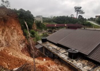 KEADAAN runtuhan tanah dari atas kawasan tinggi hampir menimbus dua buah rumah sewa yang didiami dua keluarga di Kampung Mela di Lipis, Pahang. - FOTO /IHSAN APM LIPIS
