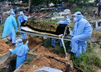 MOHAMAD Matassian Ogus bersama petugas pengurusan jenazah HQE Kota Kinabalu yang lain semasa mengebumikan salah seorang pesakit Covid-19. - IHSAN HQE