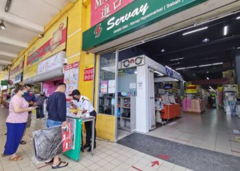 PELANGGAN mengimbas MySejahtera sebelum memasuki Servey Hypermarket Putatan, Sabah.-UTUSAN/SURAIDAH ROSLAN