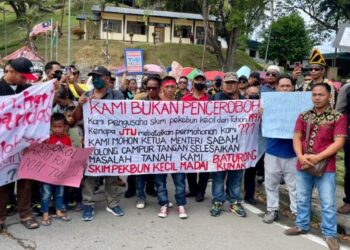 PENDUDUK tiga daerah berarak di luar Pejabat JTU Sabah di Kota Kinabalu hari ini.